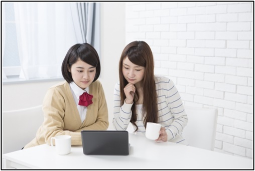 女子高生と母親がノートパソコンを見ている写真