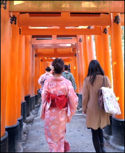 伏見稲荷神社の鳥居を歩く女性二人組の画像